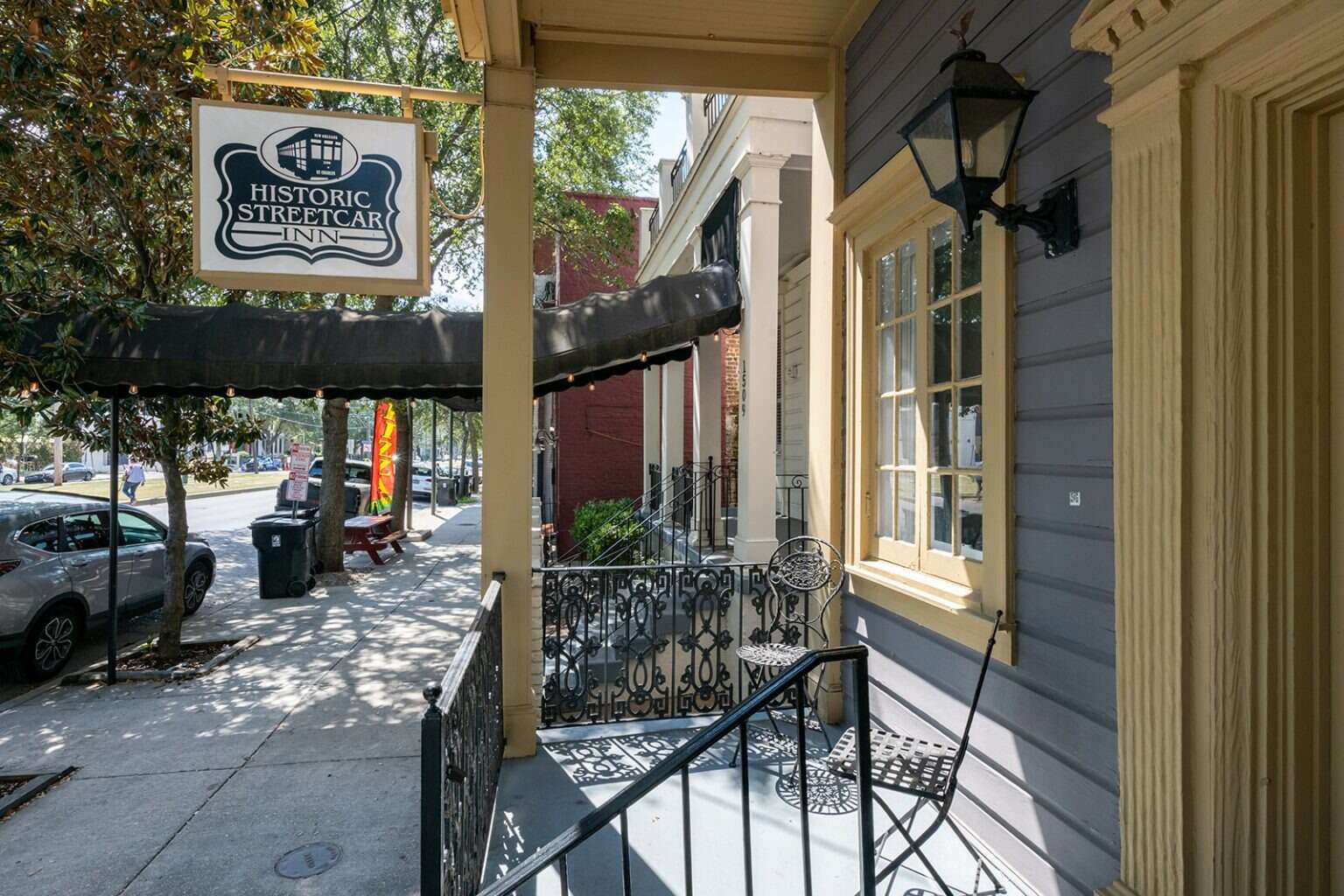 A small porch with a sign reading 'Historic Streetcar Inn' and a black railing.