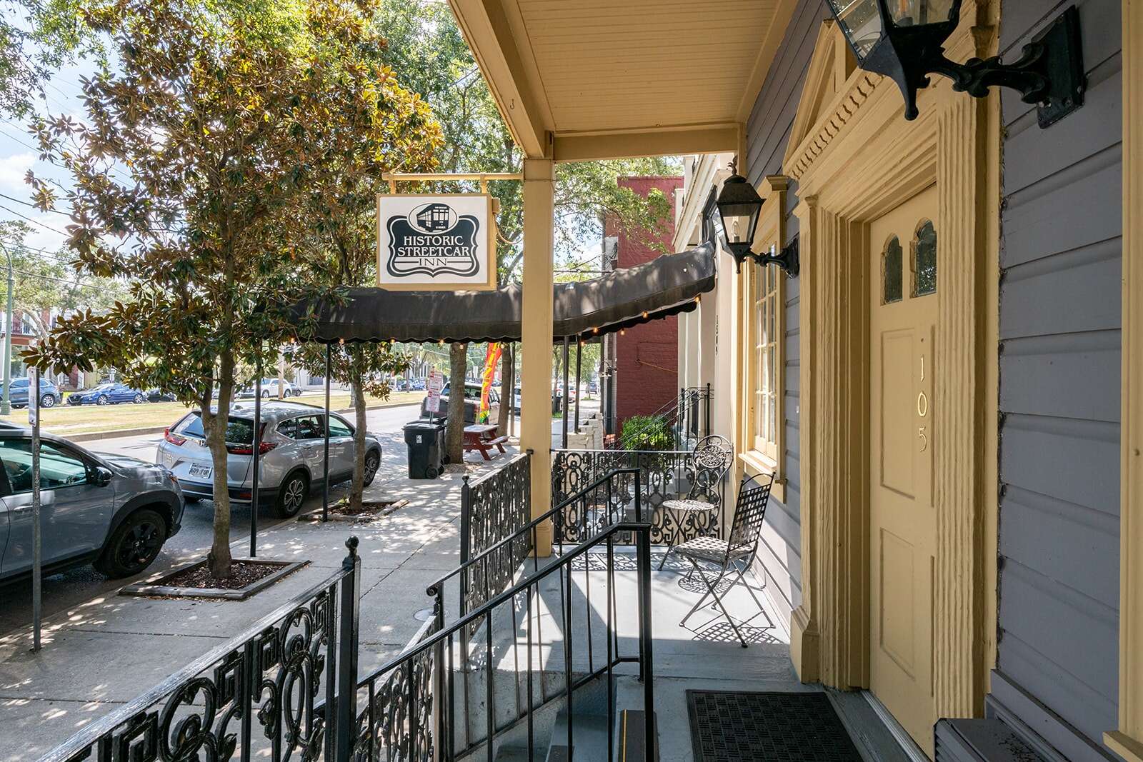 The exterior of a building with a porch, sign, and door.